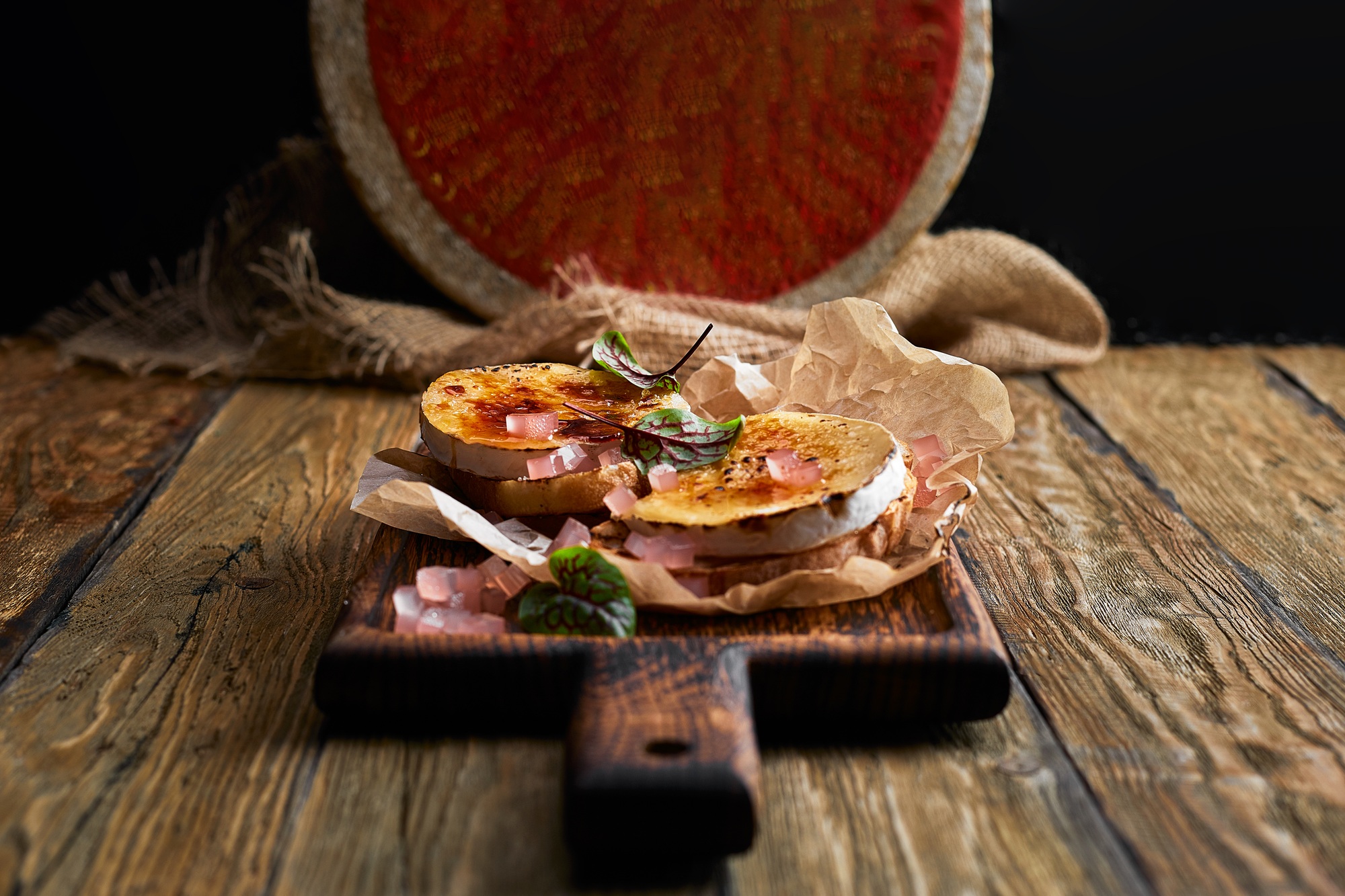 Baked Camembert cheese with toasted bread on wooden board